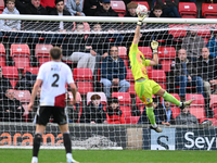 Goalkeeper Will Jaaskelainen, from Woking, tips the ball over late during the FA Cup First Round match between Woking and Cambridge United a...