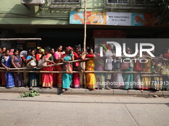 Hindu devotees stand in a queue to receive rice as offerings distributed by the temple authority on the occasion of the Annakut festival in...