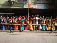 Hindu devotees stand in a queue to receive rice as offerings distributed by the temple authority on the occasion of the Annakut festival in...