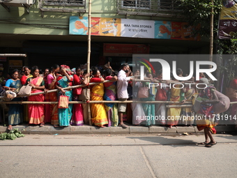 Hindu devotees stand in a queue to receive rice as offerings distributed by the temple authority on the occasion of the Annakut festival in...