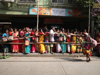 Hindu devotees stand in a queue to receive rice as offerings distributed by the temple authority on the occasion of the Annakut festival in...