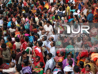 Hindu devotees wait to receive rice as offerings distributed by the temple authority on the occasion of the Annakut festival in Kolkata, Ind...