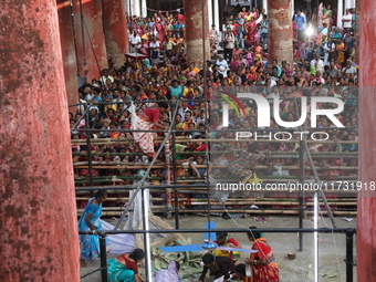 Hindu devotees cross the barricades to collect rice as offerings distributed by the temple authority on the occasion of the Annakut festival...