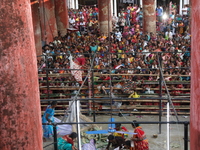 Hindu devotees cross the barricades to collect rice as offerings distributed by the temple authority on the occasion of the Annakut festival...