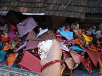 Hindu devotees hold up clothes to receive rice as offerings distributed by the temple authority on the occasion of the Annakut festival in K...