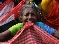 Hindu devotees hold up clothes to receive rice as offerings distributed by the temple authority on the occasion of the Annakut festival in K...