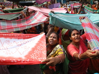 Hindu devotees hold up clothes to receive rice as offerings distributed by the temple authority on the occasion of the Annakut festival in K...