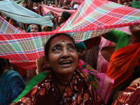 Hindu devotees hold up clothes to receive rice as offerings distributed by the temple authority on the occasion of the Annakut festival in K...