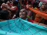 Hindu devotees hold up clothes to receive rice as offerings distributed by the temple authority on the occasion of the Annakut festival in K...