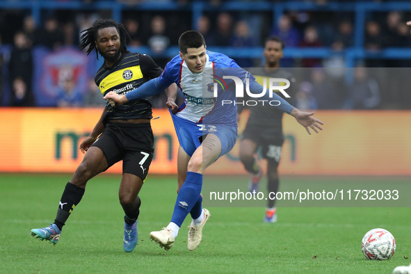 Dion Rankine of Wigan Athletic and Jon Mellish of Carlisle United battle for the ball during the FA Cup First Round match between Carlisle U...