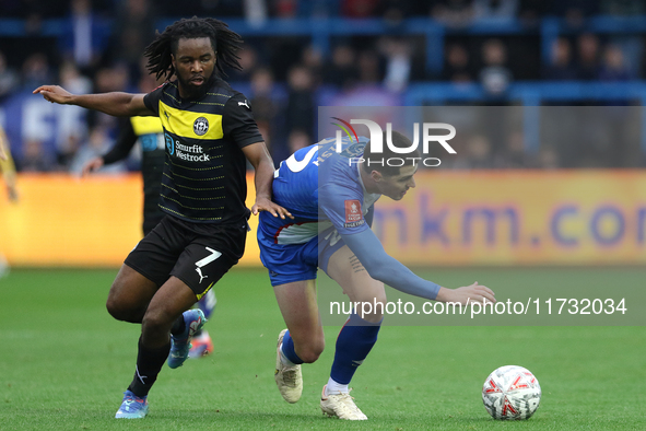 Dion Rankine of Wigan Athletic and Jon Mellish of Carlisle United battle for the ball during the FA Cup First Round match between Carlisle U...