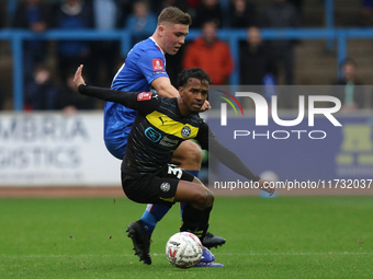 Harrison Neal of Carlisle United challenges Tyrese Francois of Wigan Athletic during the FA Cup First Round match between Carlisle United an...