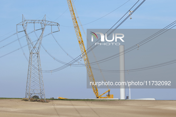 A large crane assembles a wind turbine in the rolling hills of Castelluccio dei Sauri, Foggia, Italy, on November 1, 2024. This wind farm ex...