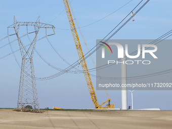 A large crane assembles a wind turbine in the rolling hills of Castelluccio dei Sauri, Foggia, Italy, on November 1, 2024. This wind farm ex...