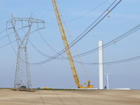 A large crane assembles a wind turbine in the rolling hills of Castelluccio dei Sauri, Foggia, Italy, on November 1, 2024. This wind farm ex...