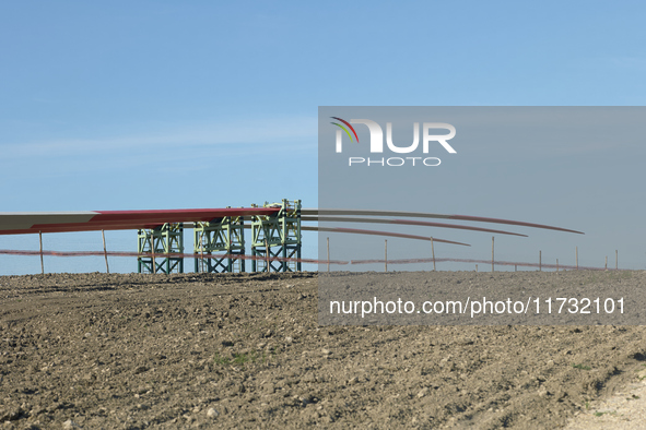 A large crane assembles a wind turbine in the rolling hills of Castelluccio dei Sauri, Foggia, Italy, on November 1, 2024. This wind farm ex...