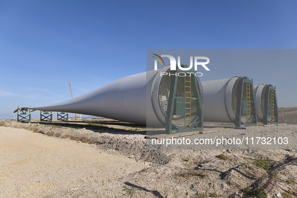 A large crane assembles a wind turbine in the rolling hills of Castelluccio dei Sauri, Foggia, Italy, on November 1, 2024. This wind farm ex...