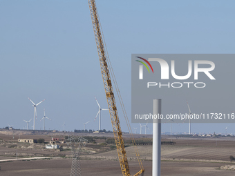 A large crane assembles a wind turbine in the rolling hills of Castelluccio dei Sauri, Foggia, Italy, on November 1, 2024. This wind farm ex...