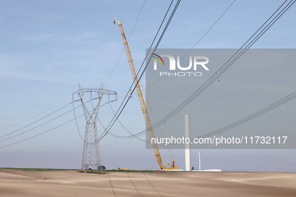 A large crane assembles a wind turbine in the rolling hills of Castelluccio dei Sauri, Foggia, Italy, on November 1, 2024. This wind farm ex...