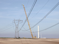 A large crane assembles a wind turbine in the rolling hills of Castelluccio dei Sauri, Foggia, Italy, on November 1, 2024. This wind farm ex...