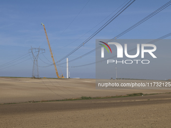 A large crane assembles a wind turbine in the rolling hills of Castelluccio dei Sauri, Foggia, Italy, on November 1, 2024. This wind farm ex...