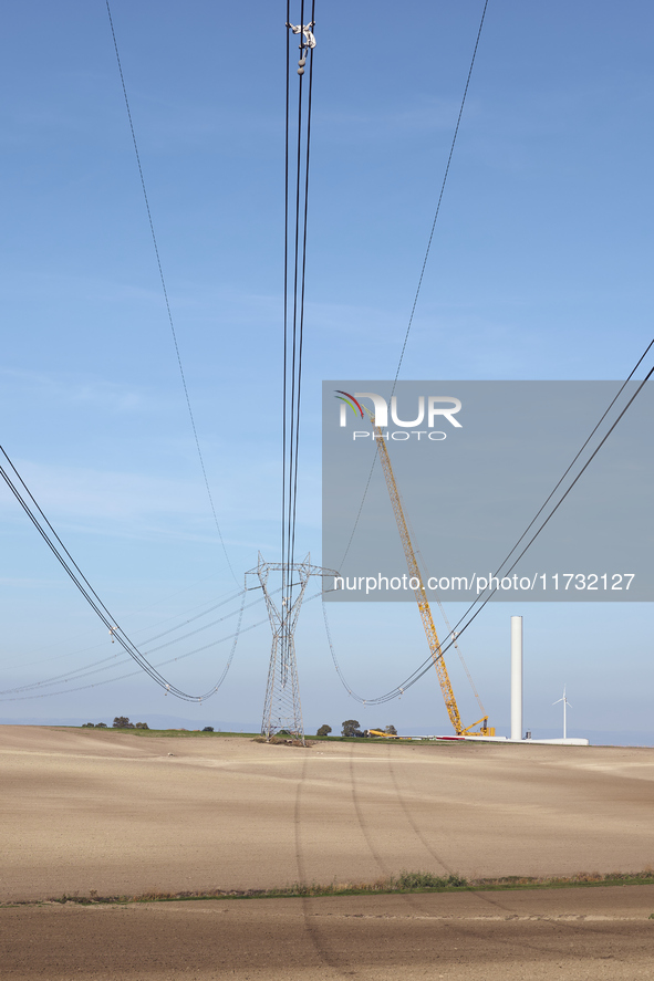 A large crane assembles a wind turbine in the rolling hills of Castelluccio dei Sauri, Foggia, Italy, on November 1, 2024. This wind farm ex...