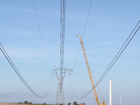 A large crane assembles a wind turbine in the rolling hills of Castelluccio dei Sauri, Foggia, Italy, on November 1, 2024. This wind farm ex...