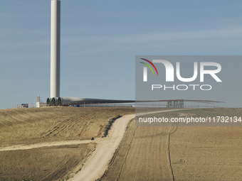 A large crane assembles a wind turbine in the rolling hills of Castelluccio dei Sauri, Foggia, Italy, on November 1, 2024. This wind farm ex...