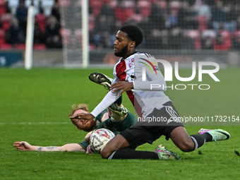 James Brophy (7, Cambridge United) is challenged by Raheem Conte (18, Woking) during the FA Cup First Round match between Woking and Cambrid...