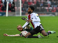 James Brophy (7, Cambridge United) is challenged by Raheem Conte (18, Woking) during the FA Cup First Round match between Woking and Cambrid...