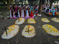 Sisters of Missionaries of Charity pray in front of graves during All Souls' Day observance at a cemetery 80 kilometers outside Kolkata, Ind...