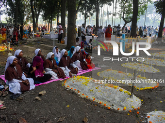 Sisters of Missionaries of Charity pray in front of graves during All Souls' Day observance at a cemetery 80 kilometers outside Kolkata, Ind...