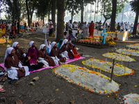 Sisters of Missionaries of Charity pray in front of graves during All Souls' Day observance at a cemetery 80 kilometers outside Kolkata, Ind...