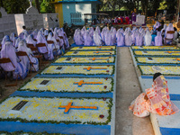 Sisters of Missionaries of Charity pray in front of graves during All Souls' Day observance at a cemetery 80 kilometers outside Kolkata, Ind...