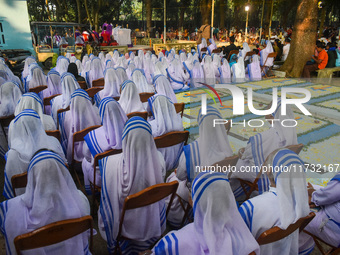 Sisters of Missionaries of Charity pray in front of graves during All Souls' Day observance at a cemetery 80 kilometers outside Kolkata, Ind...