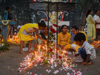 A boy lights candles over the grave of his relative during All Souls' Day observance at a cemetery 80 kilometers outside Kolkata, India, on...