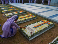 A sister of the Missionaries of Charity lights candles over a grave during All Souls' Day observance at a cemetery 80 kilometers outside Kol...