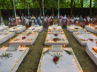 Sisters of Missionaries of Charity and children pray in front of graves during All Souls' Day observance at a cemetery 80 kilometers outside...