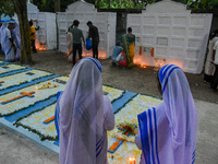 Sisters of Missionaries of Charity pray in front of graves during All Souls' Day observance at a cemetery 80 kilometers outside Kolkata, Ind...