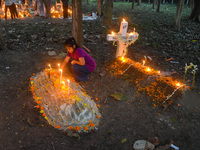 A little girl lights candles over her relative's grave during All Souls' Day observance at a cemetery 80 kilometers outside Kolkata, India,...