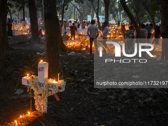 Candles are seen over graves during All Souls Day observance at a cemetery 80 kilometers outside Kolkata, India, on November 2, 2024. (