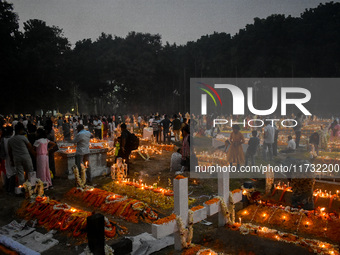 Candles are seen over graves during All Souls Day observance at a cemetery 80 kilometers outside Kolkata, India, on November 2, 2024. (