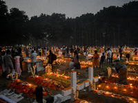 Candles are seen over graves during All Souls Day observance at a cemetery 80 kilometers outside Kolkata, India, on November 2, 2024. (