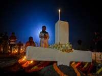 A girl prays in front of her relative's grave during All Souls' Day observance at a cemetery 80 kilometers outside Kolkata, India, on Novemb...