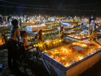 A man in a wheelchair is in front of the grave of his relative during All Souls' Day observance at a cemetery 80 kilometers outside Kolkata,...