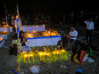 A man in a wheelchair is in front of the grave of his relative during All Souls' Day observance at a cemetery 80 kilometers outside Kolkata,...