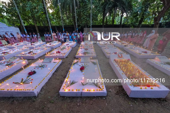 Sisters of Missionaries of Charity and children pray in front of graves during All Souls' Day observance at a cemetery 80 kilometers outside...