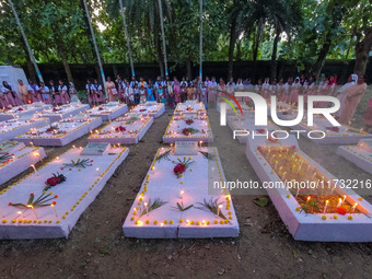 Sisters of Missionaries of Charity and children pray in front of graves during All Souls' Day observance at a cemetery 80 kilometers outside...