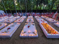 Sisters of Missionaries of Charity and children pray in front of graves during All Souls' Day observance at a cemetery 80 kilometers outside...