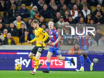 #20, Tommy Doyle of Wolves, is chased by #19, Will Hughes of Crystal Palace during the Premier League match between Wolverhampton Wanderers...